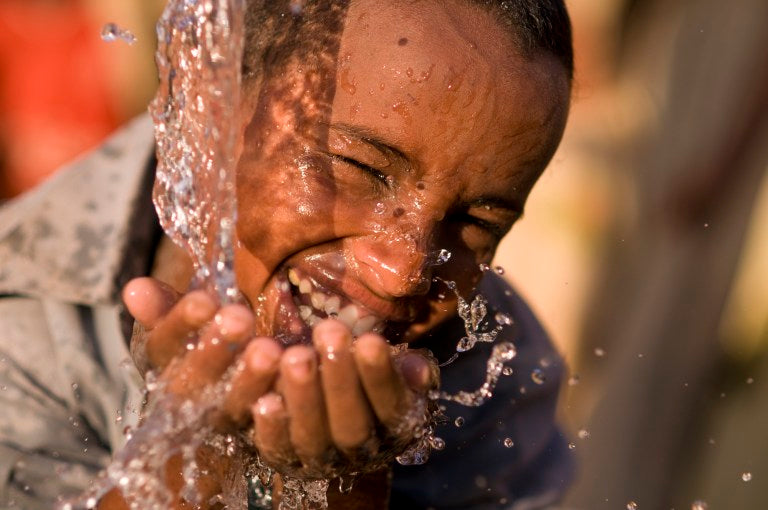 un garcon boie de l'eau